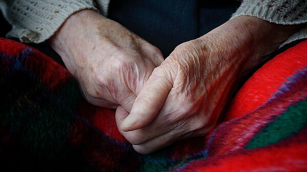 Save Winter Fuel Payments An elderly person's hands clasped together over a blanket