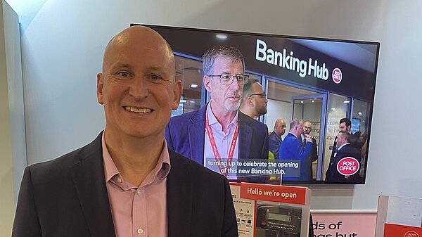 Julian standing in front of a pretend post office with a banking hub sign behind