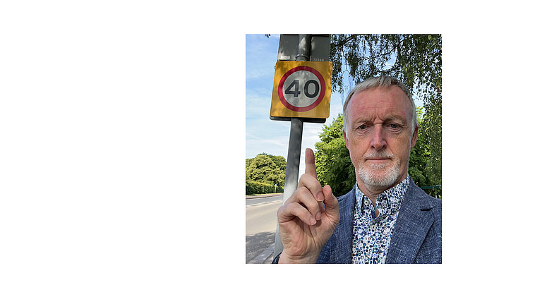 Cllr Wilson pointing at a 40mph sign